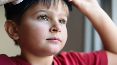Blonde small boy is looking dramatically ahead and putting on virtual reality Stock Footage 250363940