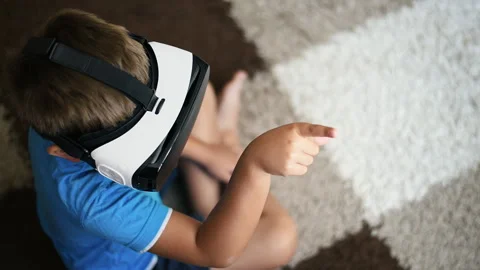 Blonde small boy is using VR headset and gesticulating Stock Footage 250364110