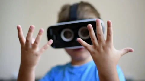 Blonde small boy wearing a virtual reality headset at home. Looking at his hands Stock Footage 250363932