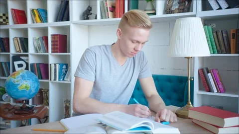 Blonde student preparing for exam in university library Stock Footage 104422371