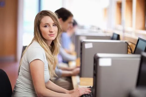 Blonde student using a computer Stockfoto's