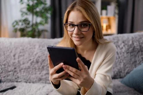 Blonde with tablet on couch Stock Photos