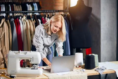 Blonde tailor has problems with computer Stock Photos