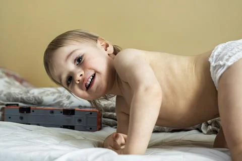 Blonde toddler smiling while lying upside down during playful moment Stock-Fotos