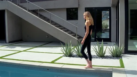 Blonde walking Along Pool Stock Footage 99480345