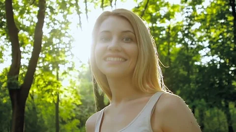 The blonde walks through the forest and turns around, smiling. Video stock 75819081
