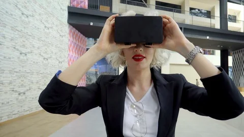 Blonde is wearing a head-mounted display and walking in a corridor of mall Video stock 86574681