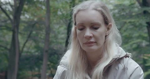Blonde woman alone and sad in forest Stock Footage