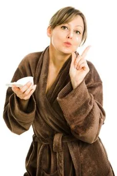 Blonde woman in big oversized brown dressing gown applying face cream - skin Stock Photos