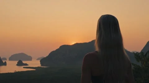Blonde Woman at Elevated Viewpoint Over Tropical Islands at Golden Hour 動画素材 332725861