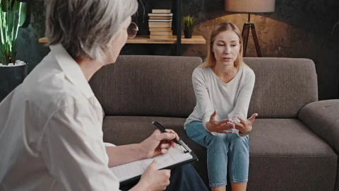 Blonde woman explains personal problem to psychologist Stock Footage 218743191
