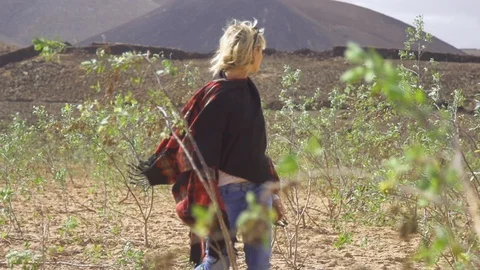 Blonde woman looking back while walking in field on a sunny day Stock Footage 85816665