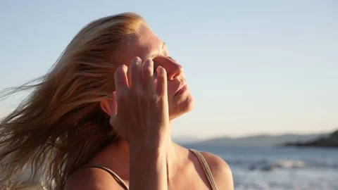 Blonde woman makes hair on the beach slow-mo Stock Footage