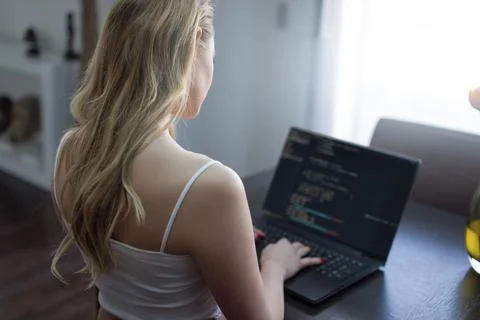 Blonde woman programmer coding on laptop at home Stock-Fotos