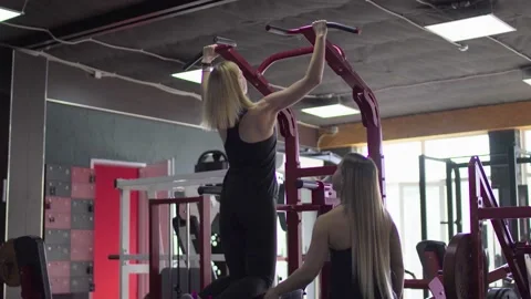 Blonde woman pulls up with support on training apparatus. Training with Stock Footage 143516387