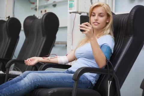 Blonde woman relaxing in a chair while getting dialysis Stock Photos