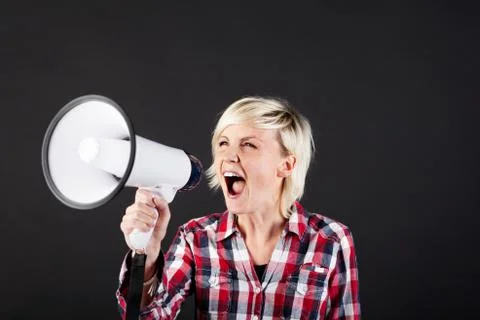 Blonde woman shouting into megaphone Stock Photos