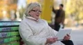 Blonde woman sits on the bench and communicates via tablet pc HD Footage