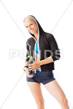 Blonde woman in sports wear holding a water bottle and smiling to the camera Stock Photos