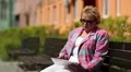 Blonde woman with tablet computer sits on the bench HD Footage