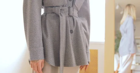 Blonde Woman Trying On The Grey Jacket With Belt In Front Of The Mirror Close-Up Stock Footage 126031653