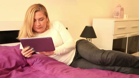 Blonde woman using digital tablet in the bedroom 2 Stock Footage 72497407