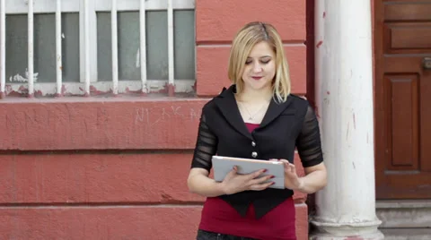 Blonde woman using tablet pc on a street Stock Footage 35011027