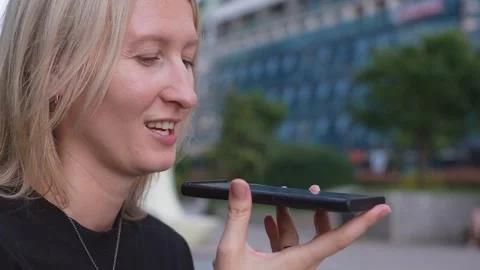 Blonde woman using voice recognition on smartphone 库存影片 338409149