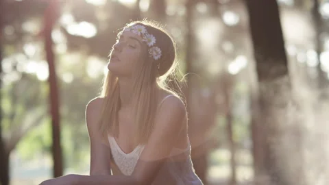 Blonde young model sitting in a bright forest Stock Footage 264011325