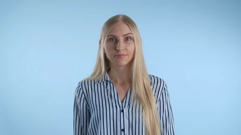 Blonde young woman misunderstanding something on blue background. Vídeos de archivo 120118853