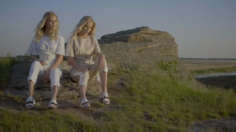 Blondes are sitting on the stone Stock Footage 92157678