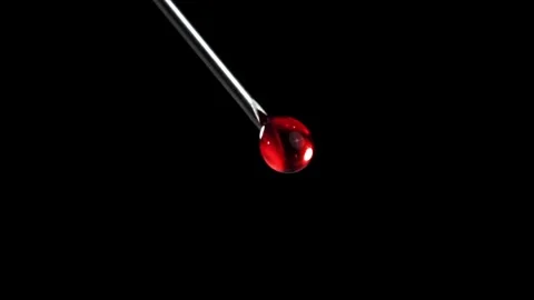 Blood Drip Falling from a Sharp Medical Needle Tip Against Black Background 库存影片 331101718