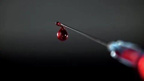 Blood Drop Falling from a Sharp Syringe Needle Against a Dark Background Vidéo 331101728