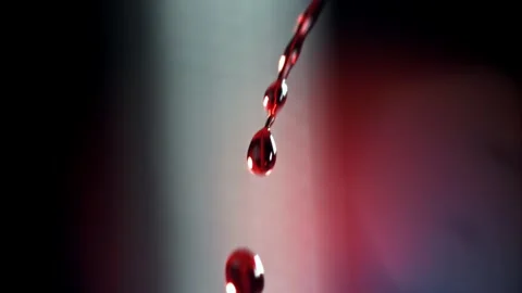 Blood Drops Falling Against a Dark Blurred Background 库存影片 331101731