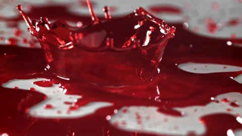 Blood Drops Splashing into a Deep Red Liquid Pool on a Light Surface 库存影片 331101674