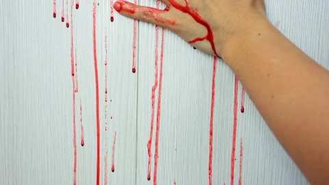 Blood flow on the wall, a human in danger. A female hand reaches out, holding on Video stock 128151187