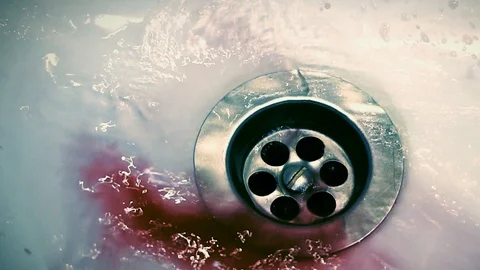 Blood flows into the drain hole of the bath. suicide. a cut. horror Stock Footage