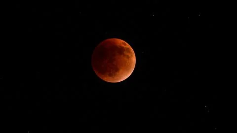 Blood moon during a lunar eclipse in the night sky. The moon appears red as.. Stock Photos