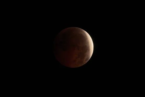 Blood Moon during a lunar eclipse in dark night sky Stock Photos