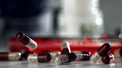 Blood Sample Testing with Medicine Capsules Falling Onto a Laboratory Desk Stock Footage 331101604