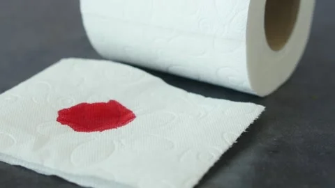 A blood spot is noticeable on a tissue next to a roll of toilet paper in the Stock Footage 286287937