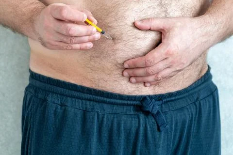 Blood thinners concept.Man is making injection in his stomach Stock Photos