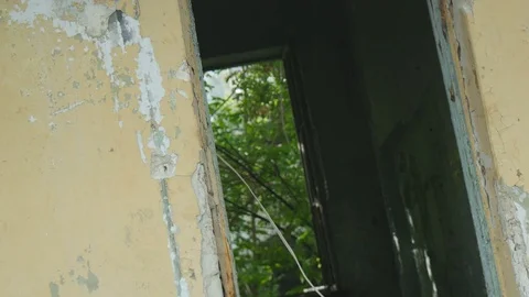 Bloody crazy guy look out of the doorway of an abandoned house Stock Footage