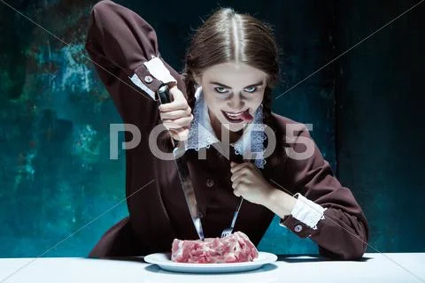 Bloody Halloween theme: crazy girl with a knife, fork and meat Stock Photos