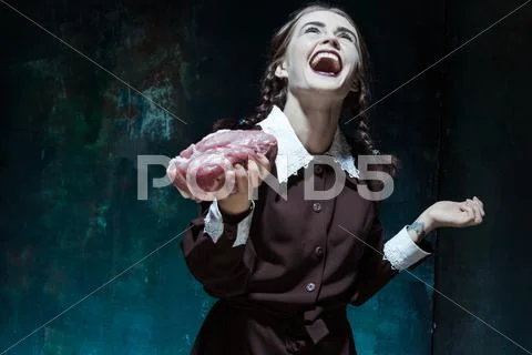 Bloody Halloween theme: crazy girl with raw meat Stock Photos