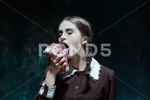 Bloody Halloween theme: crazy girl with raw meat Stock Photos