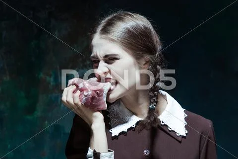 Bloody Halloween theme: crazy girl with raw meat Stock Photos