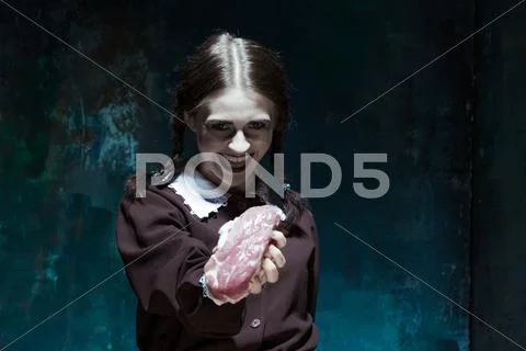 Bloody Halloween theme: crazy girl with raw meat Stock Photos