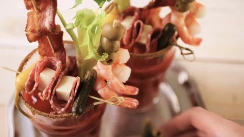 Bloody mary cocktail garnished with celery sticks, olives, and bacon strips. Stock Footage