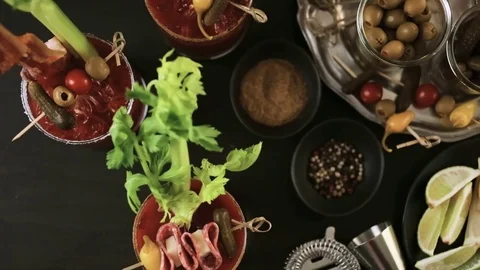 Bloody mary cocktail garnished with celery sticks, olives, and bacon strips. Stock Footage